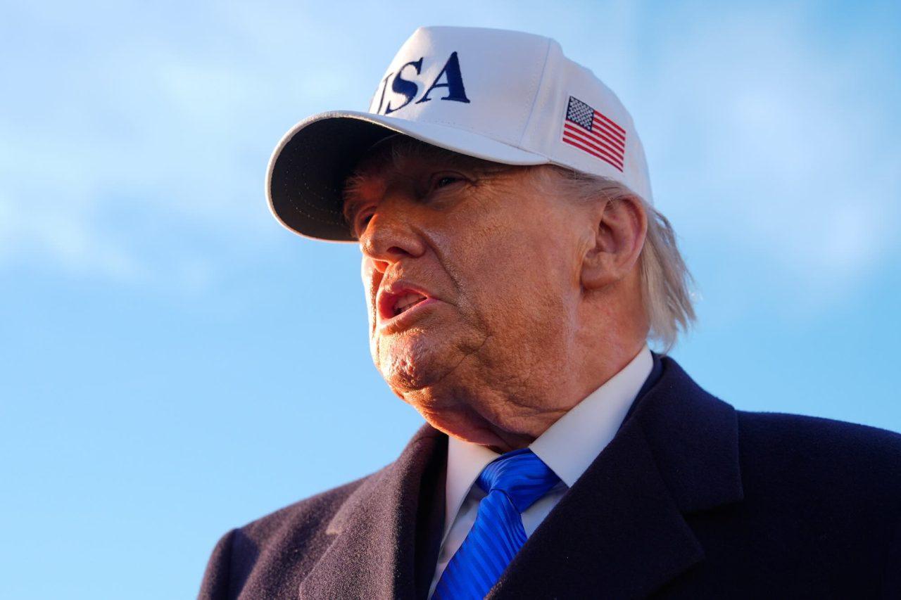 Närbild på president Donald Trump iförd en vit keps med amerikanska flaggan på sidan.